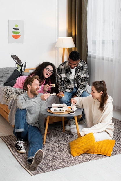 Free Photo full shot smiley friends eating sushi