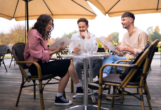 Free photo full shot smiley friends at restaurant