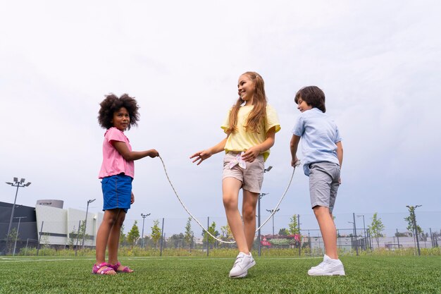 Full shot smiley girl jumping rope