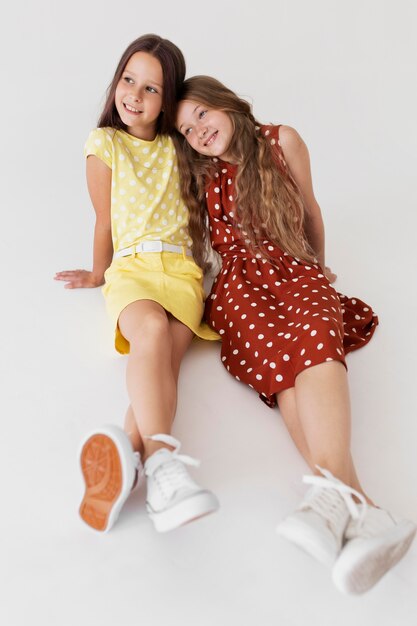 Full shot smiley girls wearing dresses