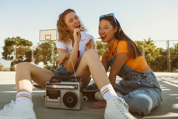 Free photo full shot smiley girls with lollipops