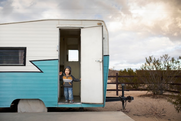 Full shot smiley kid in camper van