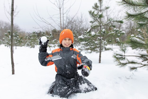 Full shot smiley kid playing with snow