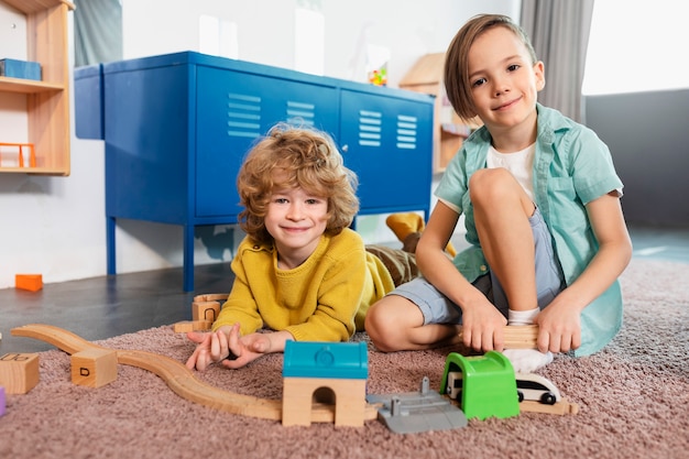 Full shot smiley kids playing together with train