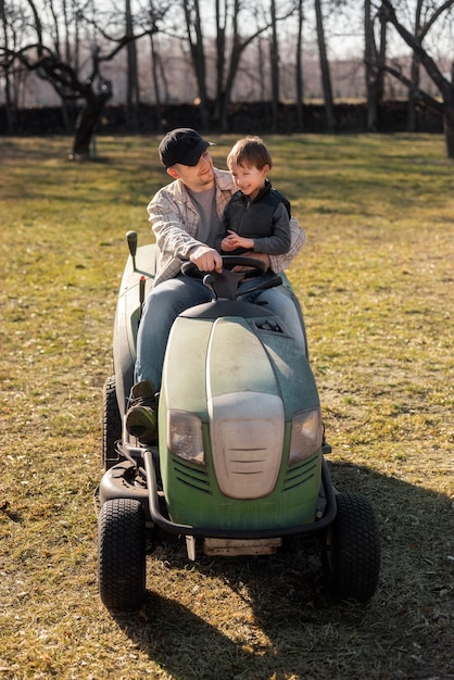 Free Photo full shot smiley man driving lawn mower