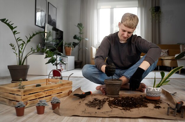 Full shot smiley man gardening at home