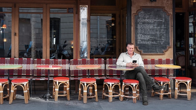 Full shot smiley man sitting at bistro