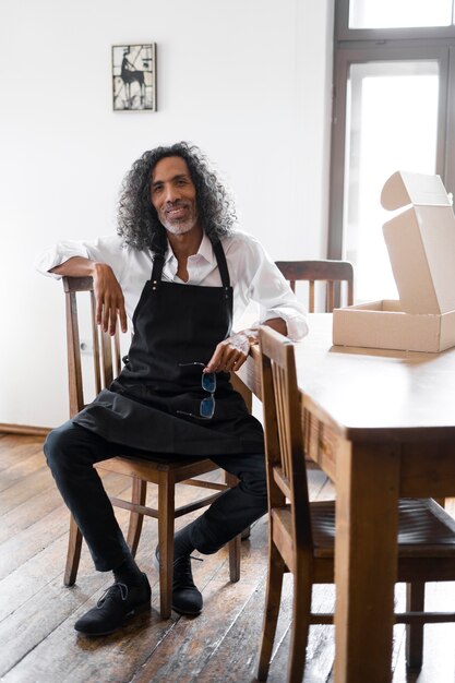 Full shot smiley man sitting on chair