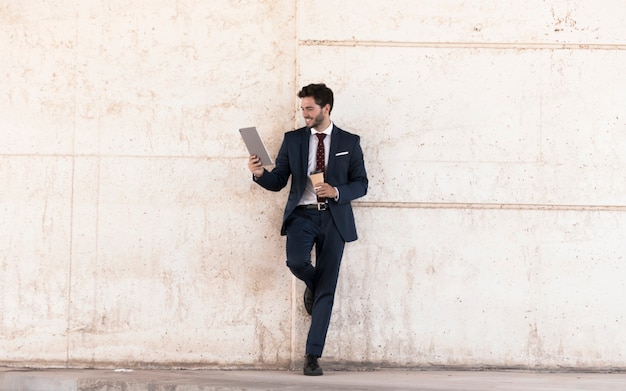 Free photo full shot smiley man with tablet and coffee