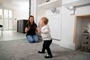 Free photo full shot smiley mother and kid inside