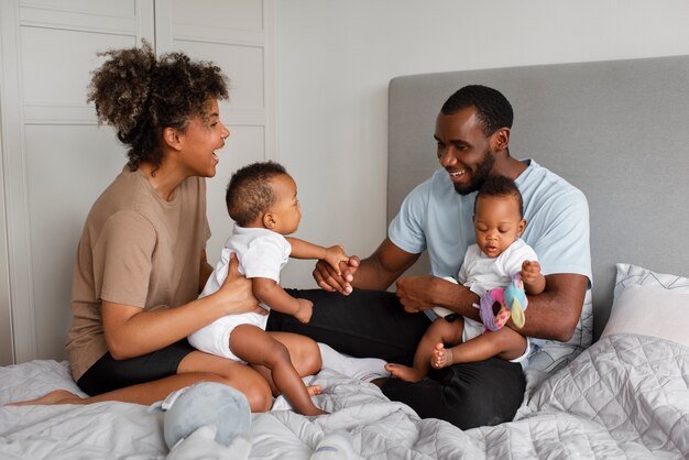 Full shot smiley parents with babies