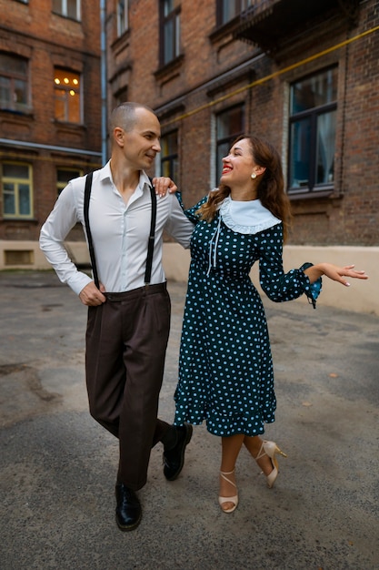 Full shot smiley people dancing outdoors