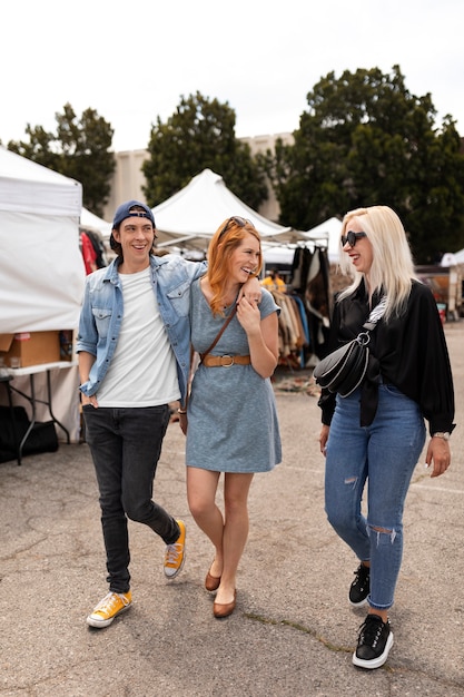 Free Photo full shot smiley people at flea market