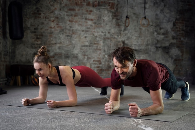 Free photo full shot smiley people training on yoga mat