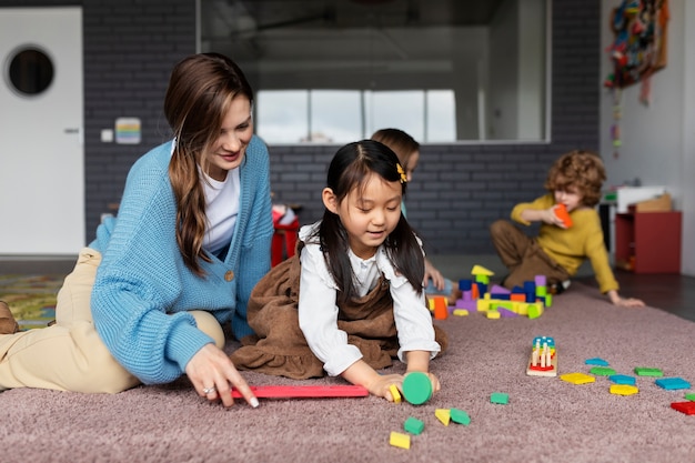 Full shot smiley teacher helping girl learn