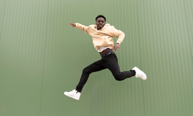 Full shot smiley teen jumping