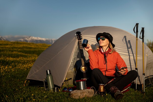 Full shot smiley woman camping with tent