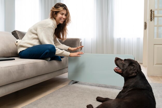 Full shot smiley woman and dog at home