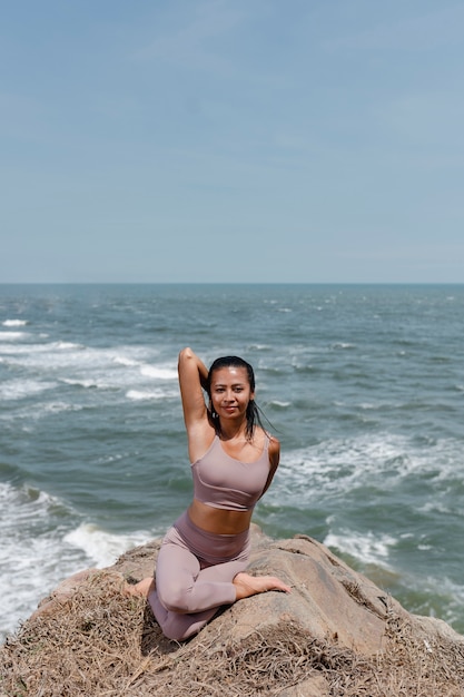 Full shot smiley woman doing yoga in nature