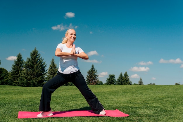 Full shot smiley woman exercising outdoors