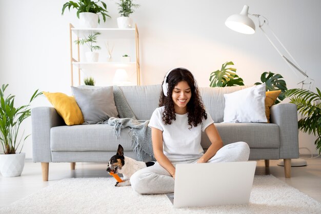 Full shot smiley woman on floor with laptop