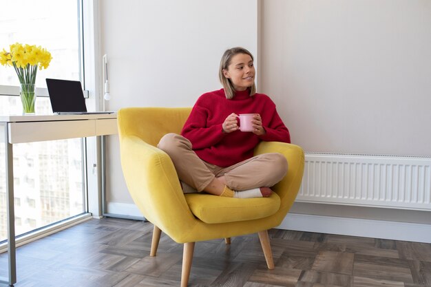 Full shot smiley woman holding coffee cup