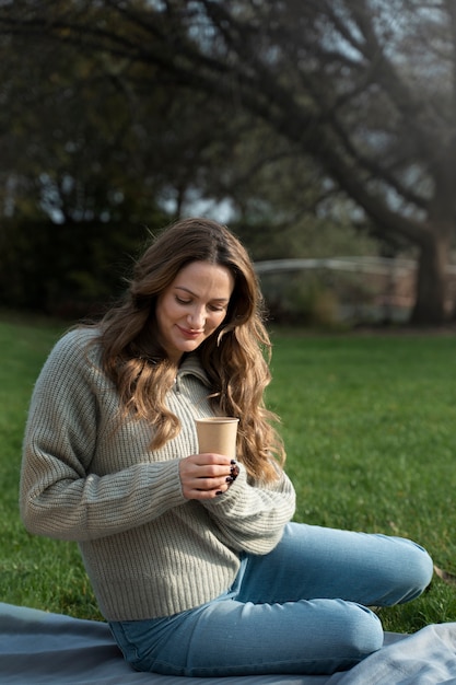 Free photo full shot smiley woman holding cup