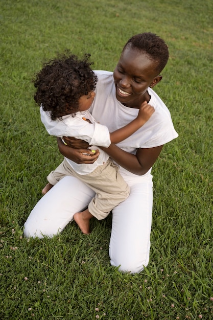 Full shot smiley woman holding kid