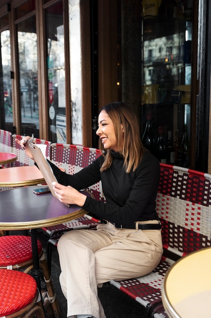 Free photo full shot smiley woman holding menu