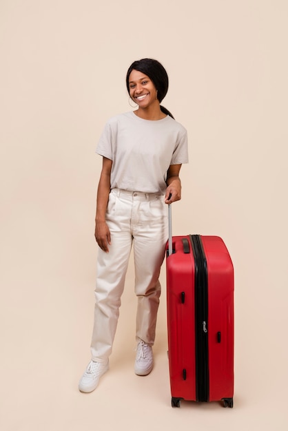 Full shot smiley woman holding red baggage