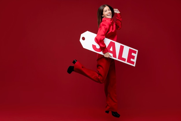 Free photo full shot smiley woman holding sale sign