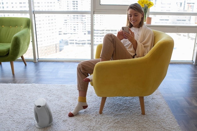 Full shot smiley woman holding smartphone