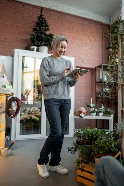 Free photo full shot smiley woman holding tablet