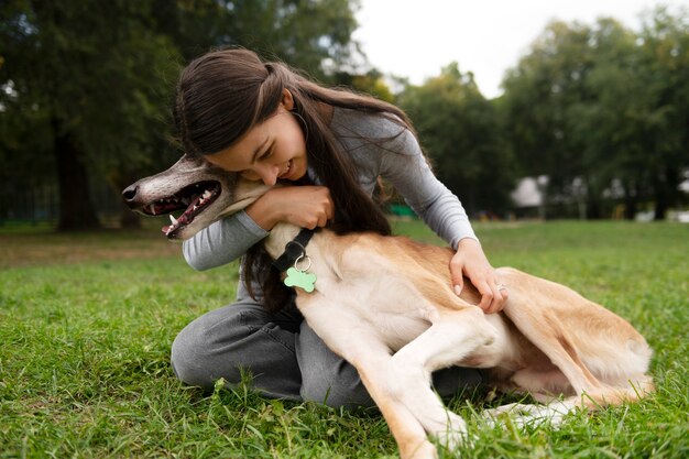 Full shot smiley woman hugging dog