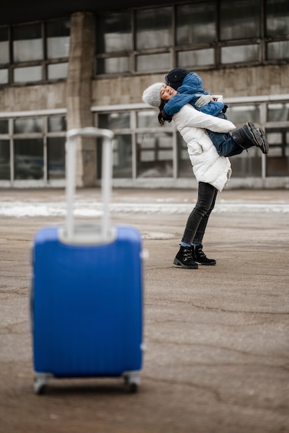 Free photo full shot smiley woman hugging kid outdoors