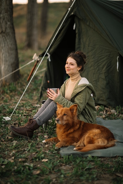 Full shot smiley woman near tent