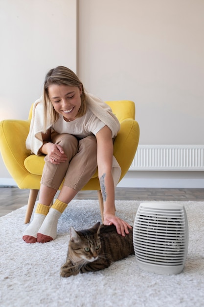 Free photo full shot smiley woman petting cat