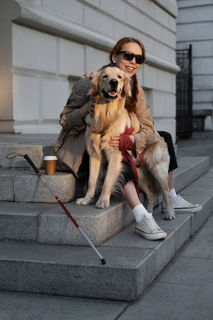 Full shot smiley woman petting service dog