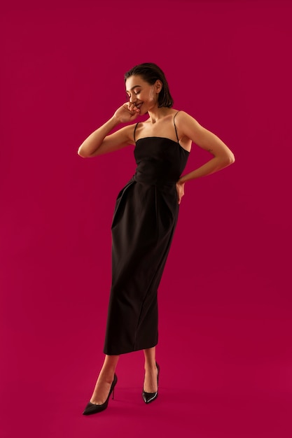 Full shot smiley woman posing in black dress