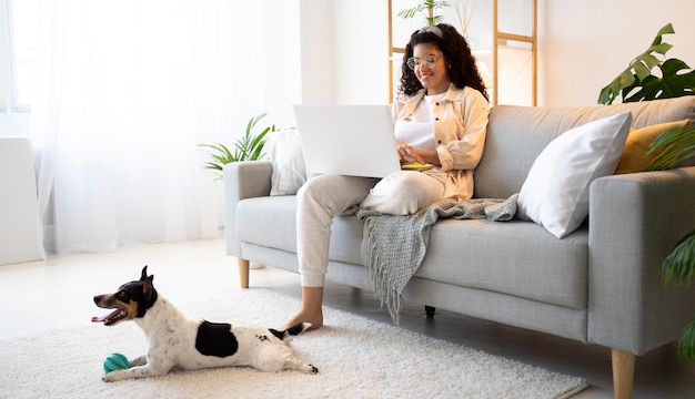 Full shot smiley woman sitting on couch