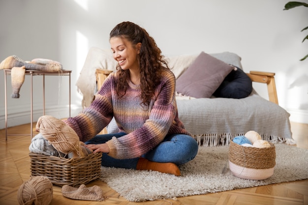 Full shot smiley woman sitting on floor