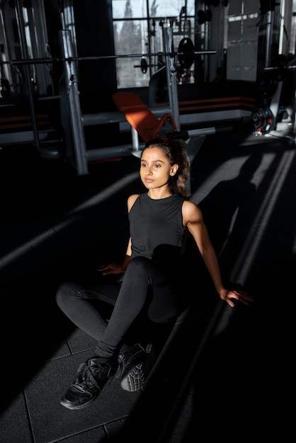 Full shot smiley woman sitting at gym