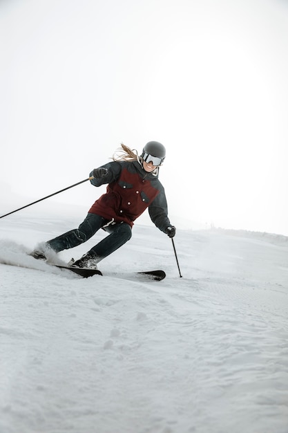 Full shot smiley woman skiing outdoors