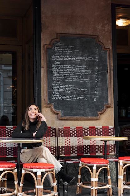 Full shot smiley woman talking on phone