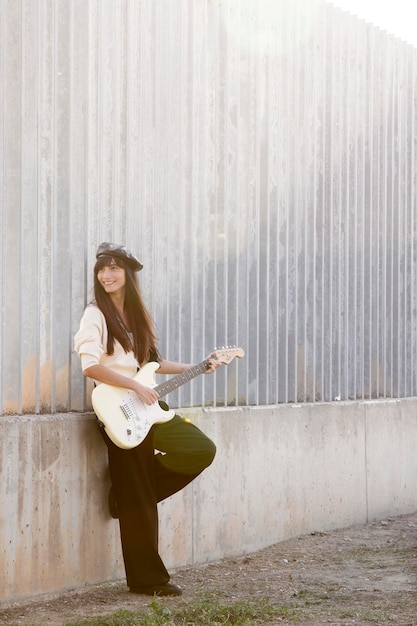 Free photo full shot smiley woman with guitar