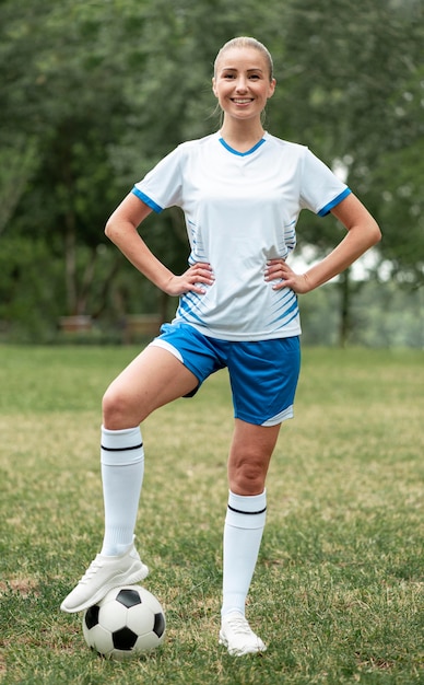 Free photo full shot smiley woman with soccer ball