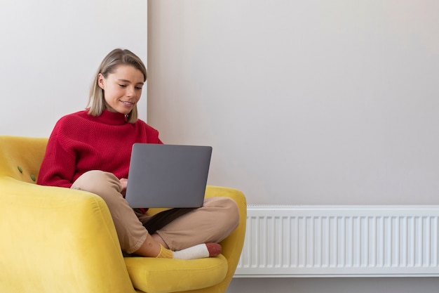 Full shot smiley woman working on laptop