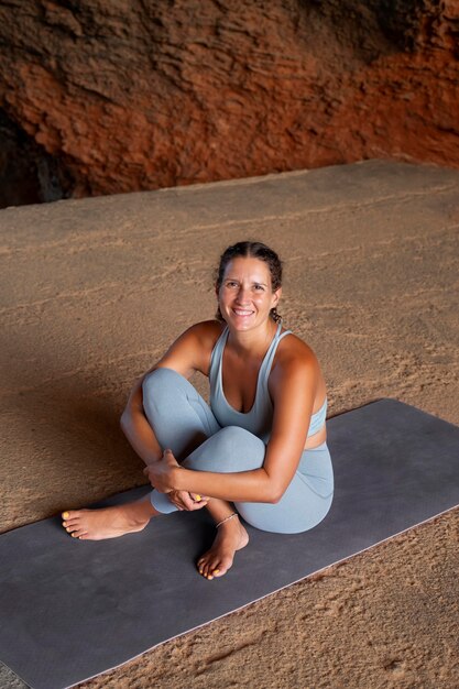 Full shot smiley woman on yoga mat