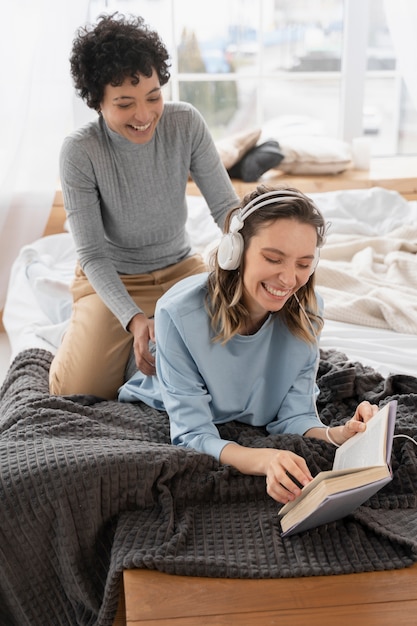 Free photo full shot smiley women in bed