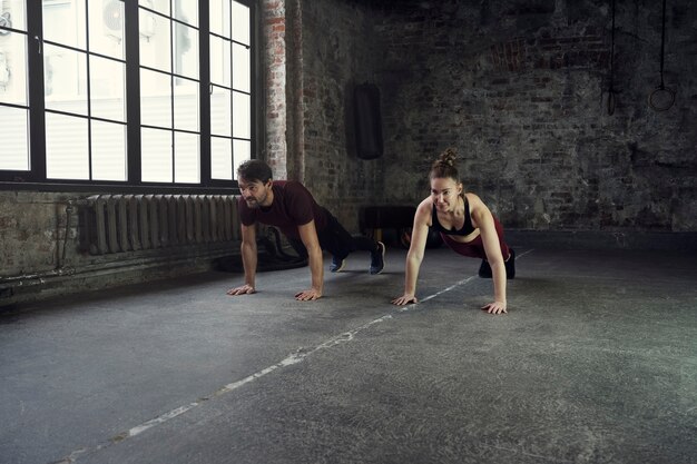 Full shot sports people doing burpees